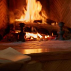 a fire is burning in a fireplace with paper on the floor