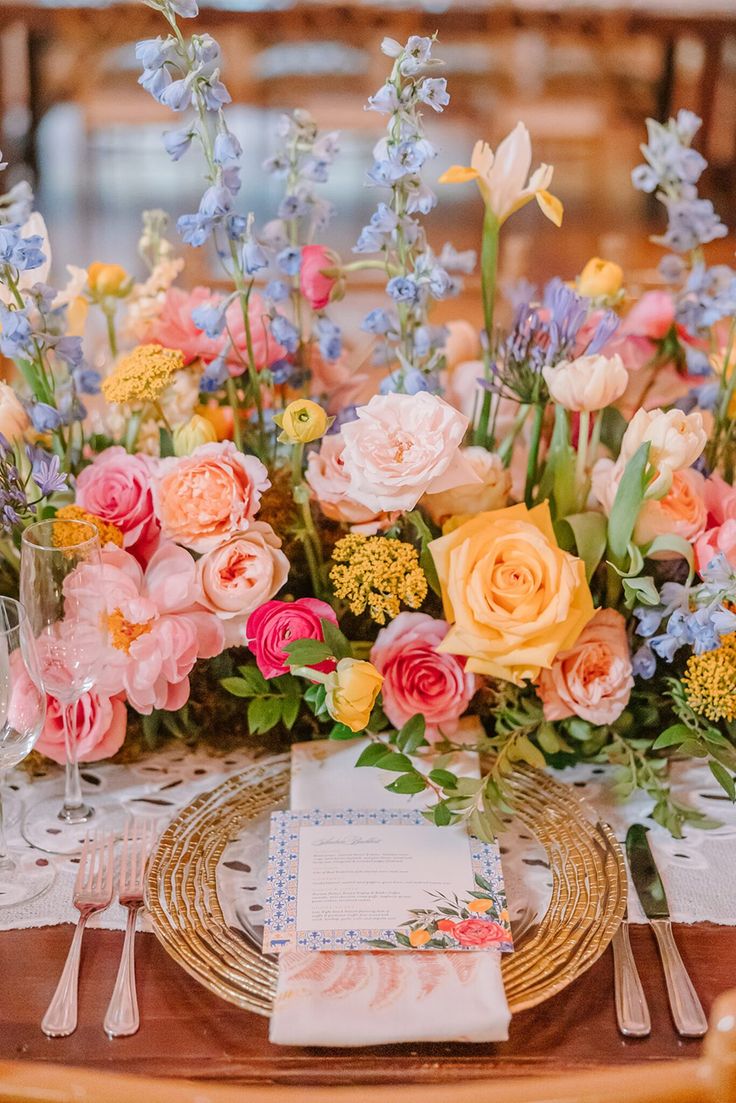 a table with flowers and place settings on it