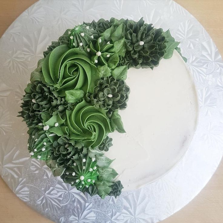 a cake decorated with green flowers and greenery