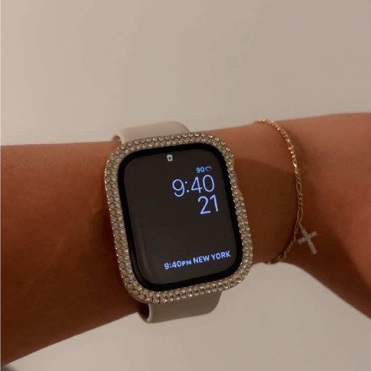 a woman's wrist with an apple watch displaying the time on it and diamond - encrusted bracelets