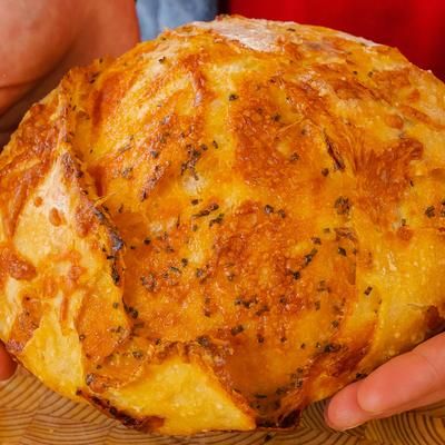 a person holding a large piece of bread in their hands