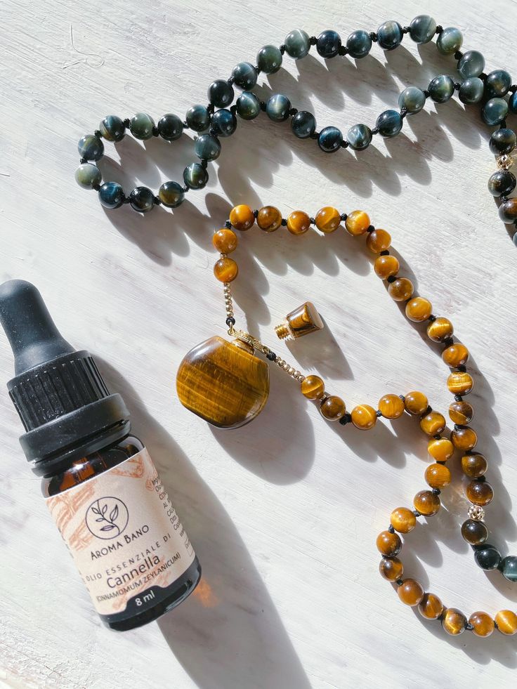 L'ho chiamata ✨Magic Bottle✨ A Mala 📿 un po' alternativa, che porta con sé l'incredibile energia dell'unione dell'occhio di Tigre e dell'occhio di Falco. Da utilizzare sia come strumento tattile per portarti nello stato meditativo ma anche per portare con te gli oli essenziali preferiti con te. Per questo Mala ho usato Tiger Eye che trovi come ciondolo e perline (6mm), Tiger Eye dorato (6mm) e Hawk Eye (6mm). La collana è stata arricchita con perline dorate. Ogni design è unico! Il tuo acquisto Amber Crystal Pendant Necklace For Meditation, Amber Pendant Crystal Necklace For Meditation, Amber Crystal Necklace For Meditation With Natural Stones, Bohemian Amber Crystal Necklace For Meditation, Round Crystal Amulet Necklaces For Meditation, Spiritual Amber Necklace For Healing, Spiritual Crystal Round Pendant Necklace For Meditation, Amulet Style Crystal Necklace For Meditation, Round Amber Necklaces For Meditation