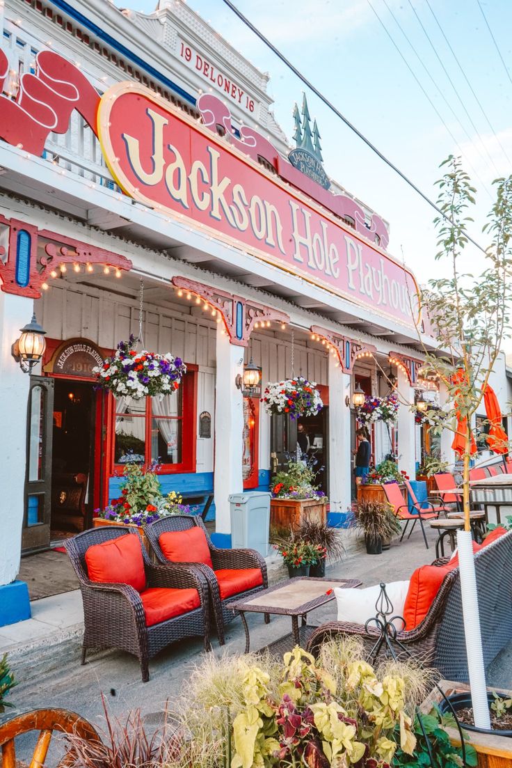 an outdoor cafe with chairs and tables on the outside, surrounded by potted plants