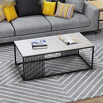 a living room with grey couches, yellow pillows and a coffee table in the middle