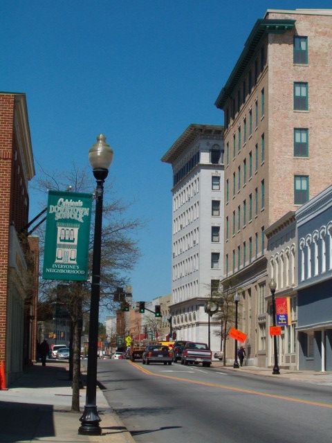 an empty city street with tall buildings in the background