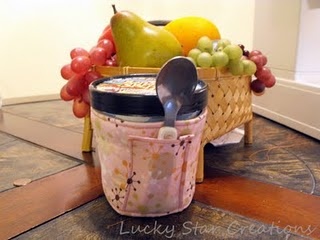 there is a jar with spoons in it on the table next to some fruit