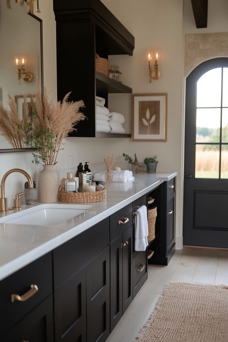 a large bathroom with black cabinets and white counter tops is pictured in this image, there are towels on the sink