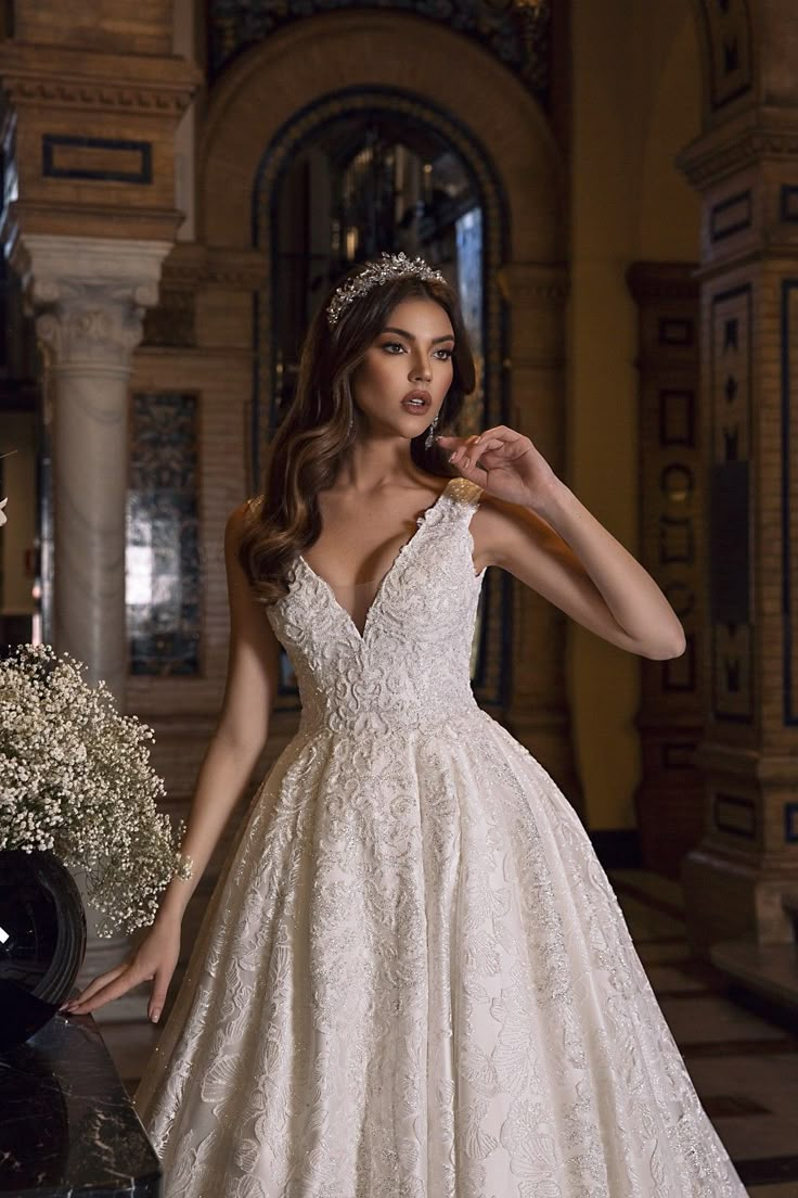 a woman in a wedding dress posing for the camera with her hand on her hip