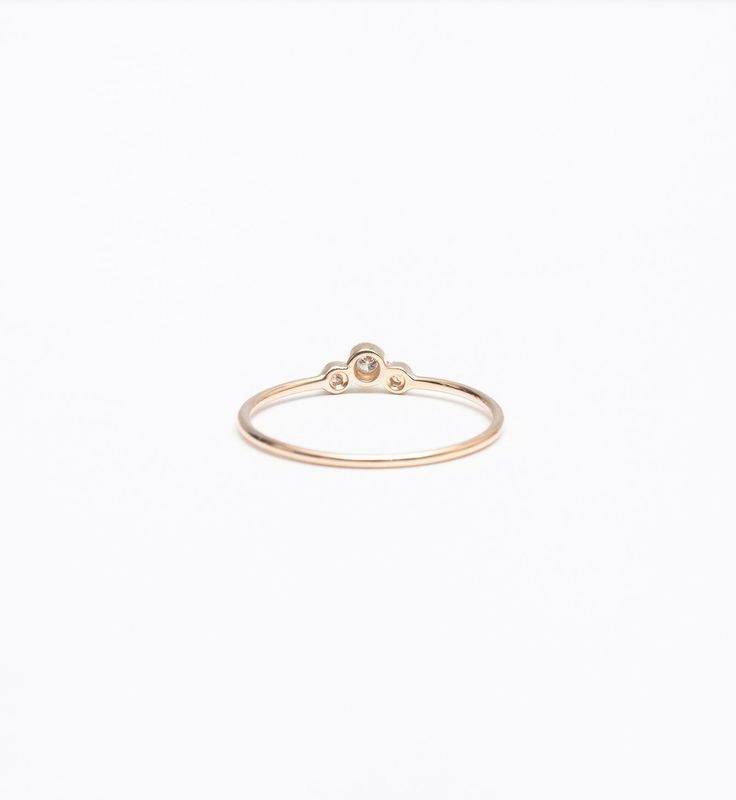 A slightly larger center and offset, delicate sides impart this delicate stacking ring with just the right amount of size and an unexpected silhouette. Though you can easily wear it on its own, you'll find a million ways to stack it thanks to the tiny space its curved design makes. Nestle it alongside other delicate rings for a multitude of sparkle or let it snuggle alongside a chunkier signet ring for maximum impact. Made in the U.S.A. Center setting measures 0.25" wide. 14 karat gold with thre Stackable Diamond Midi Rings With Round Band, Everyday Stackable Rings With Single Diamond, Everyday Stackable Diamond Ring With Round Band, Modern Stackable Diamond Midi Rings, Classic Stackable Rings With Bezel Setting, Open Ring Shape, Everyday Stackable Rose Cut Diamond Rings, Minimalist Stackable Rings With Round Diamond Band, Minimalist Diamond Stackable Rings With Round Band, Minimalist Adjustable Rings With Smooth Bezel