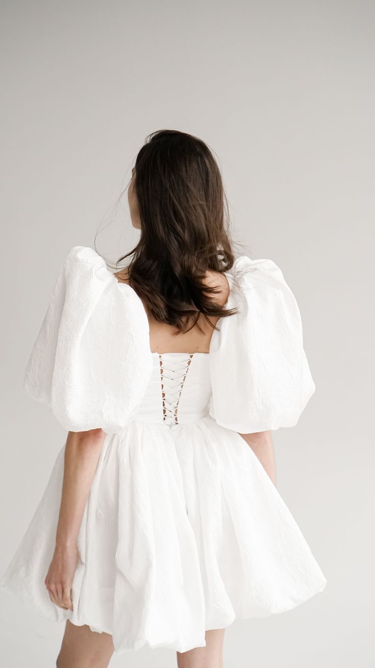 the back of a woman wearing a white dress