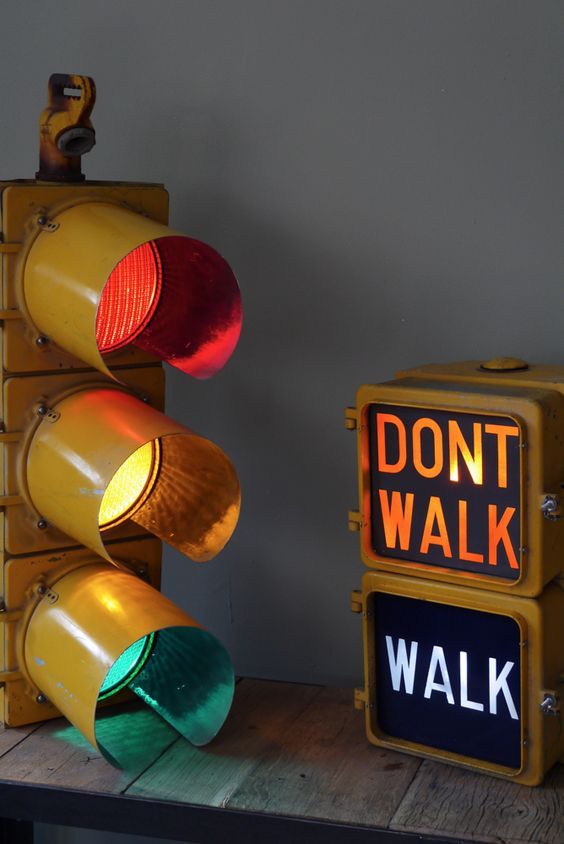 two traffic lights sitting next to each other on top of a wooden table with a don't walk sign