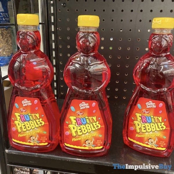 three bottles of fruit pebbles on display in a store