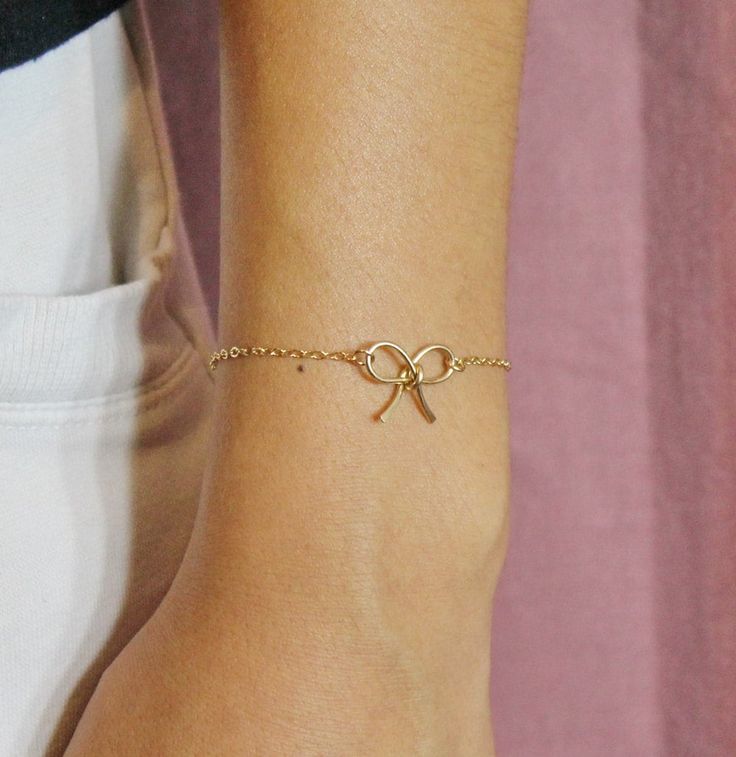 Classic dainty gold bow tie bracelet, made from 14K gold filled wire. The bracelet can be made with a personalized tag initial, just select from the option, if you ordered with an initial, don't forget to write the initial along with the order. A simply every day wear bracelet for yourself,  a gift for loved one, friends, bridesmaids, for birthday, anniversary and all occasions. Chain length can be custom selected from 5 inches to 9 inches. All findings are 14K gold filled. The same style bow ti Gold Dainty Bow Jewelry, Dainty Gold Jewelry With Bow Detail, Delicate Adjustable Gold Bracelet For Gift, Delicate 14k Gold Filled Bracelet For Gift, Delicate 14k Gold Filled Bracelet As Gift, Gold Wedding Jewelry With Butterfly Knot Detail, Elegant Adjustable Bracelet With Bow, Elegant Adjustable Bracelet With Bow Detail, Elegant Adjustable Bracelets With Bow Detail