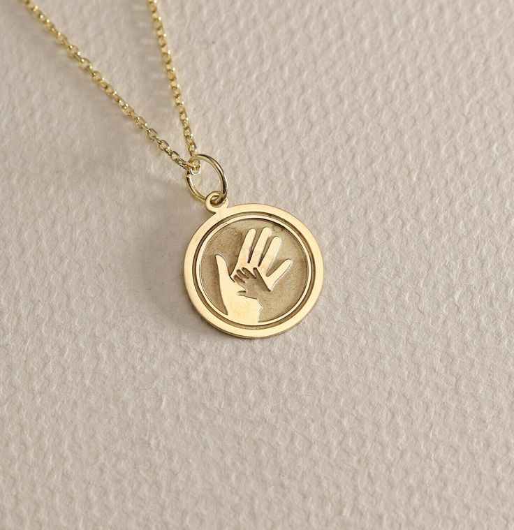 14K Real Solid Gold mother and child hands gold necklace ● Material of pendant: Solid Gold 14k ( REAL GOLD ) ● Metal Stamp: 14L ( REAL GOLD ) ● The pendant is available in 6 sizes: - 14,0 mm / 0,55 inches ( Diameter ) In the photos - 15,3 mm / 0.60 inches ( Diameter ) - 16,5 mm / 0,65 inches ( Diameter ) - 19,1 mm / 0,75 inches ( Diameter ) - 21 mm / 0,82 inches ( Diameter ) - 23 mm / 0.90 inches ( Diameter ) ( In the photos the size is 14mm / 0.55 inches Diameter ) ( Jump Ring inner diameter: 4 14k Gold Stamped Charm Necklace For Mother's Day, Yellow Gold Charms Necklaces For Mother's Day, Yellow Gold Charms Necklace For Mother's Day, Yellow Gold Initial Pendant Jewelry As Gift For Mom, Mother's Day Gold Polished Jewelry, Mother's Day Polished Gold Jewelry, Personalized Yellow Gold Charm Necklace In Recycled Gold, Gold Necklace With Polished Finish For Mother's Day, Gold Polished Necklace For Mother's Day