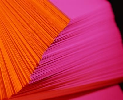 several orange and pink papers stacked on top of each other