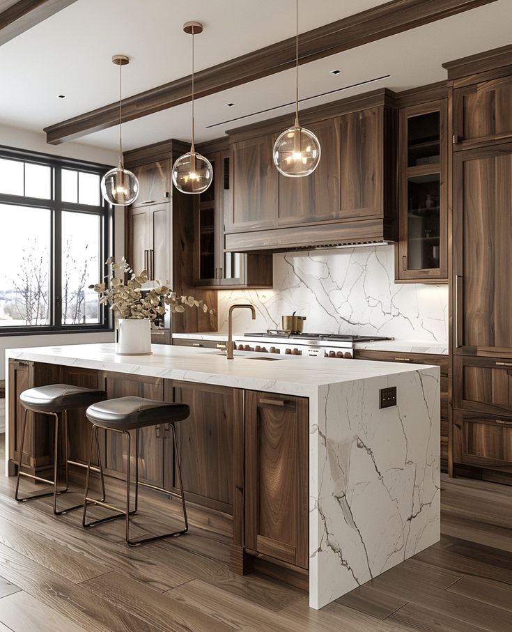 a large kitchen with marble counter tops and wooden cabinets, along with two bar stools