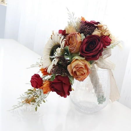 a vase filled with lots of flowers on top of a white table next to a window