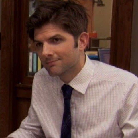 a man wearing a shirt and tie sitting at a desk