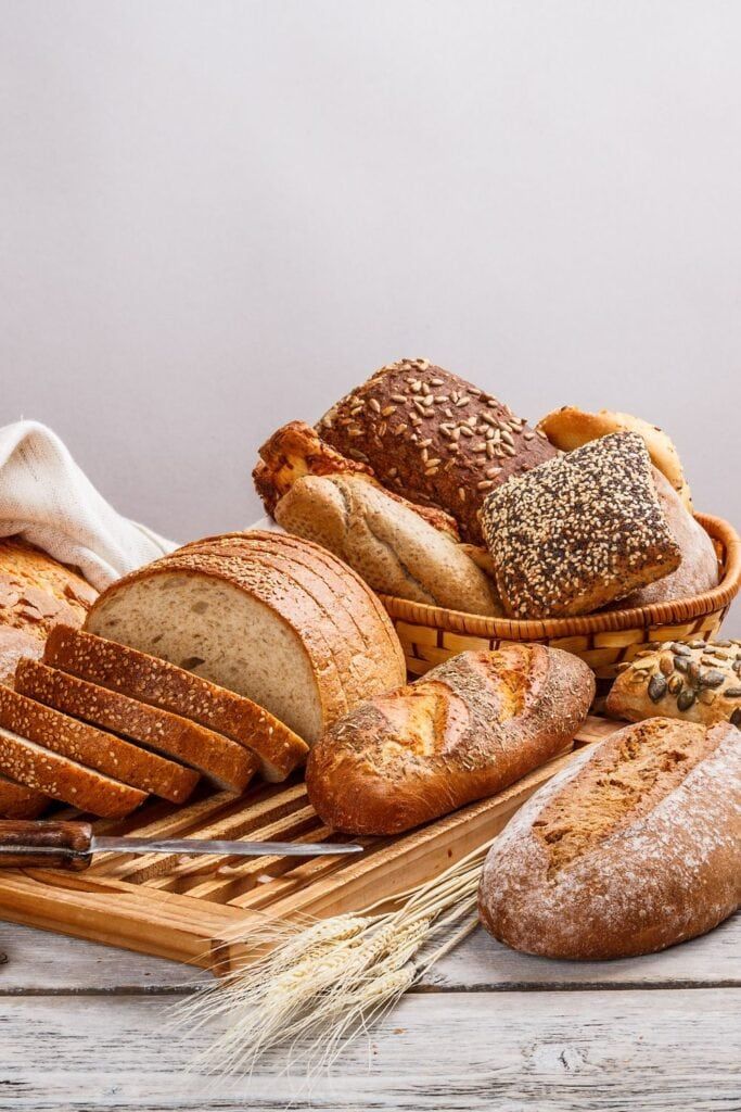 breads, loaves and wheat on a wooden table