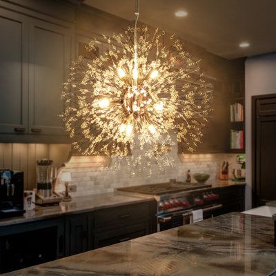 a chandelier hanging from the ceiling in a kitchen with granite counter tops and cabinets