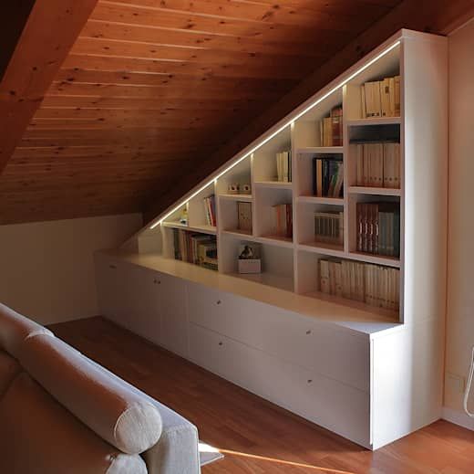 a living room filled with furniture and bookshelves next to a wall mounted book shelf