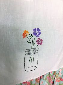 a white shirt with flowers in a mason jar on it