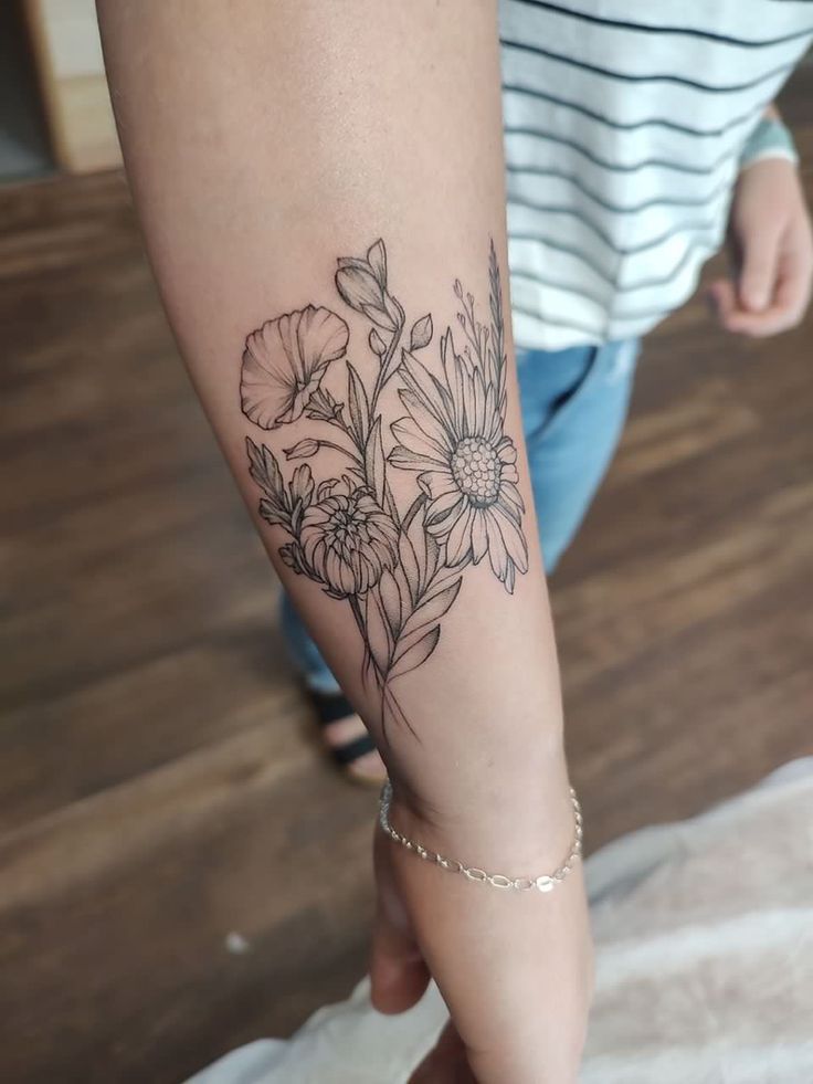 a woman's arm with flowers on it