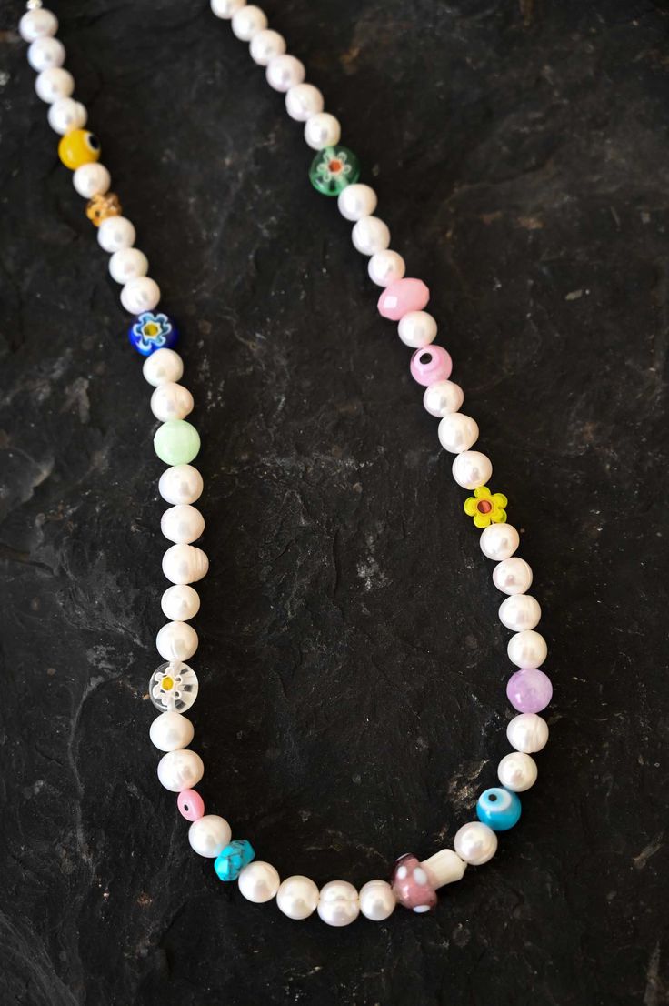 Revive the child in you with this playful and colorful Mother of Pearl charm necklace with assorted fun and colorful kidult beads. This necklace is a beautiful mix of classic elegance and youthful energy. The white Mother of Pearl beads give a timeless touch, while the kidult beads add a pop of color and playfulness. Mother of Pearl is a gemstone that is said to promote inner peace and emotional balance. The kidult beads add a touch of whimsy and fun, making this necklace a perfect accessory for Cute White Necklace With Round Beads, Cute White Necklaces With Round Beads, Cute White Jewelry With Beaded Chain, Cute White Beaded Chain Necklace, Whimsical White Necklaces For Gifts, Cute Everyday Necklaces With Colorful Beads, Whimsical White Necklace For Gift, Whimsical White Necklace Perfect For Gifts, Cute White Everyday Necklace