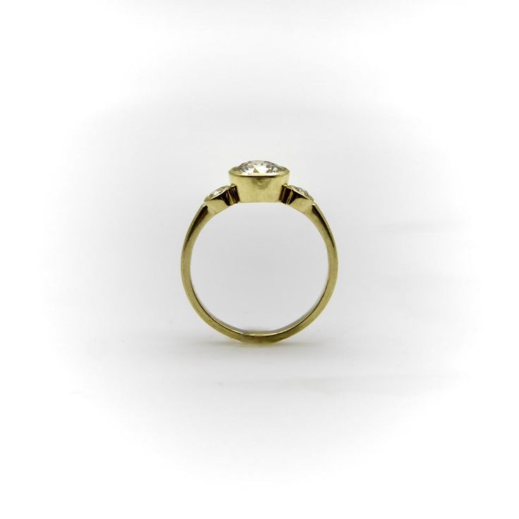 a yellow gold ring with a single diamond in the center and two small diamonds on each side