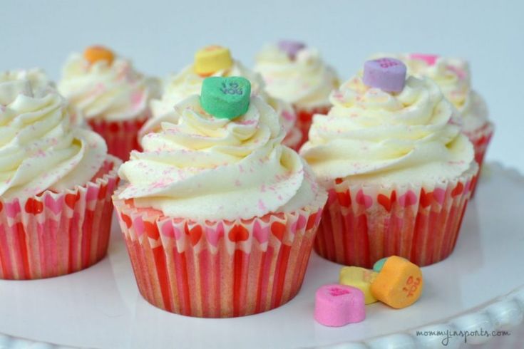 cupcakes with white frosting and colorful decorations