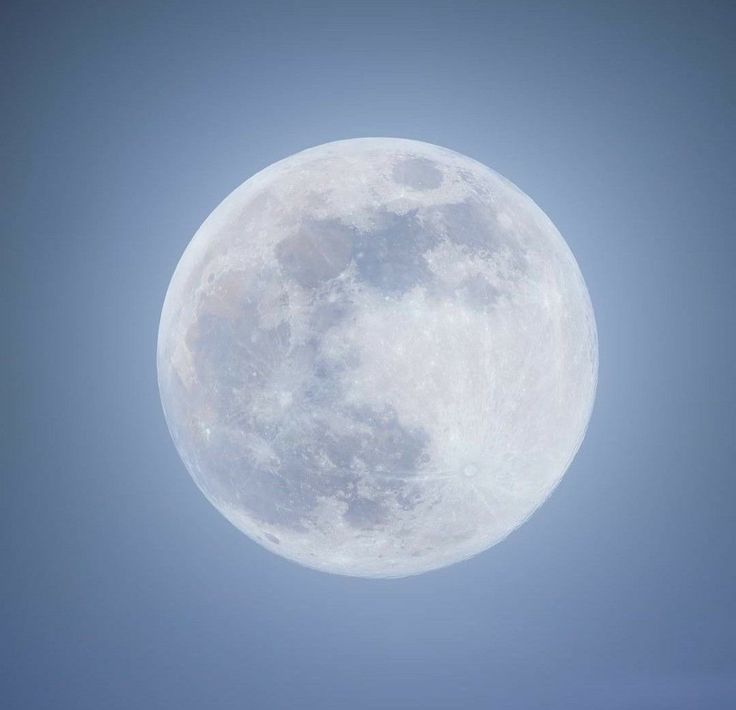 an airplane flying in the sky with a full moon behind it's back end