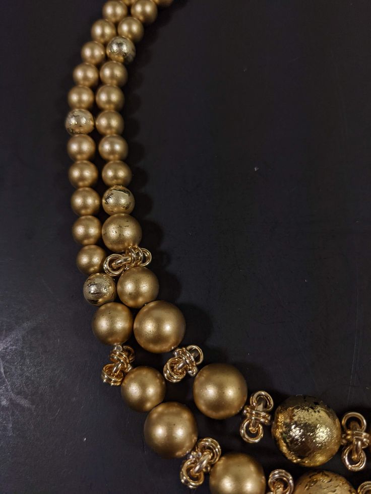 This vintage necklace has 2 strands of gold tone beads. It measures 18 inches long with a hook style clasp. It has only very light wear. R Party Gold-tone Necklace With Gold Beads, Gold Multi-strand Pearl Necklace, Gold Multi-strand Layered Necklace With Beads, Gold Necklace With Beaded Chain For Party, Gold Beaded Multi-strand Layered Necklace, Gold Beaded Necklaces With Polished Beads For Party, Gold Multi-strand Jewelry With Polished Beads, Gold Multi-strand Necklace With Gold Beads, Gold Single Strand Beaded Necklace For Party