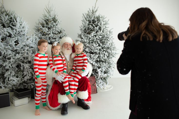 a group of children dressed up as santa and mrs claus in front of christmas trees