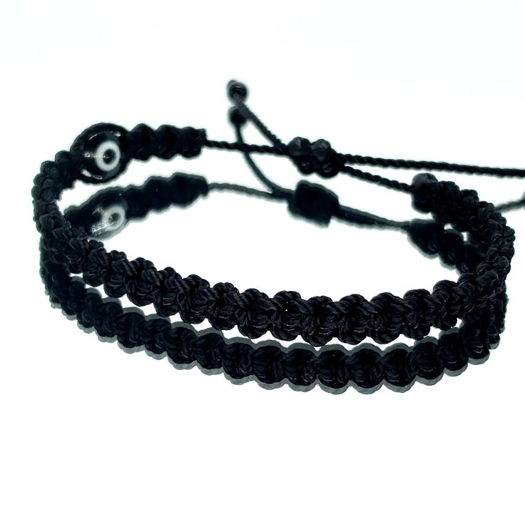 Hand-Made Black String Bracelet With An Evil Eye For Wrist Sizes 6 To 9 Inches, With An Easy To Use Zip Like Function To Fit Your Wrist. Made From High Quality Black String, It Will Be Sure To Last. Wearing An Evil Eye As An Amulet Is Believed To Provide Protection Against Evil Forces. The Evil Eye Meaning Has Symbolism In Almost Every Country In The World And In Every Religion. Each Bracelet Is Carefully Handcrafted And Give Proper Time To Ensure Quality. Elegant Black Bracelet With Adjustable Cord, Black Beaded Bracelets With Adjustable Cord As Gift, Black Beaded Bracelet With Adjustable Cord As Gift, Casual Handmade Black Friendship Bracelets, Elegant Black Braided Bracelets For Friendship, Casual Black Band Wristband Bracelet, Casual Black Wristband Bracelet, Elegant Black Braided Bracelets, Adjustable Black Beads Wristband Gift