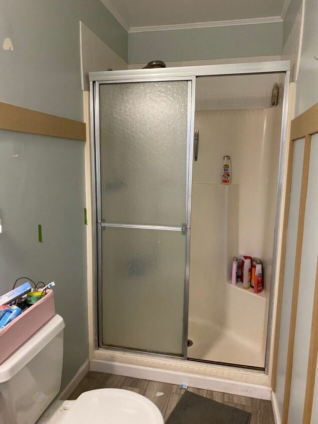 a bathroom with a shower, toilet and sink in it's stall area next to the bathtub