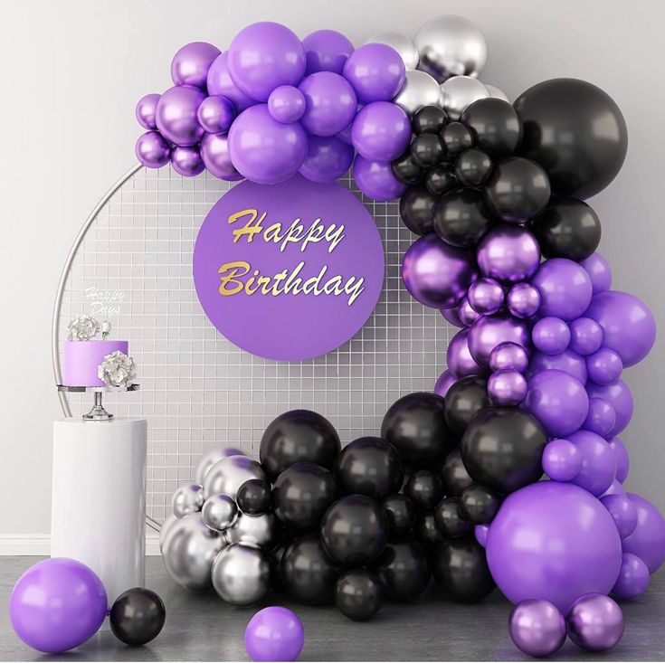 a purple and black balloon arch with happy birthday sign