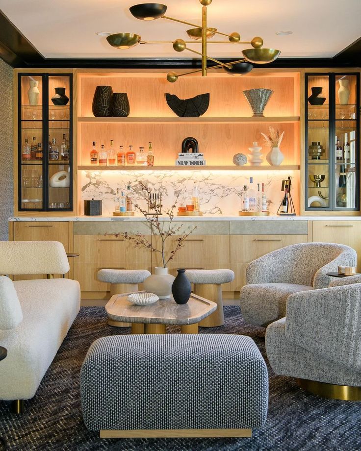 a living room filled with furniture and a bar in the back drop off cabinet behind it