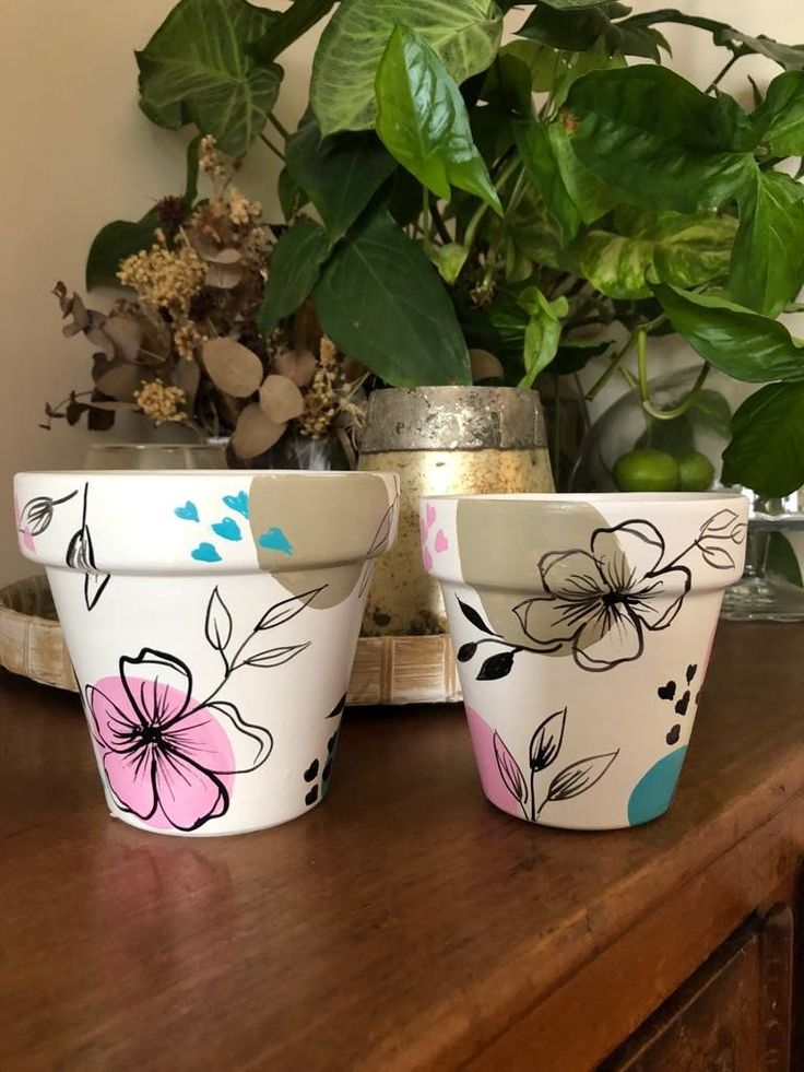 three flower pots sitting on top of a wooden table