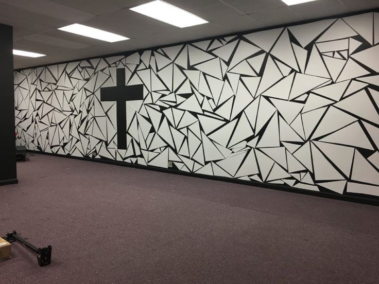 an empty room with a cross painted on the wall