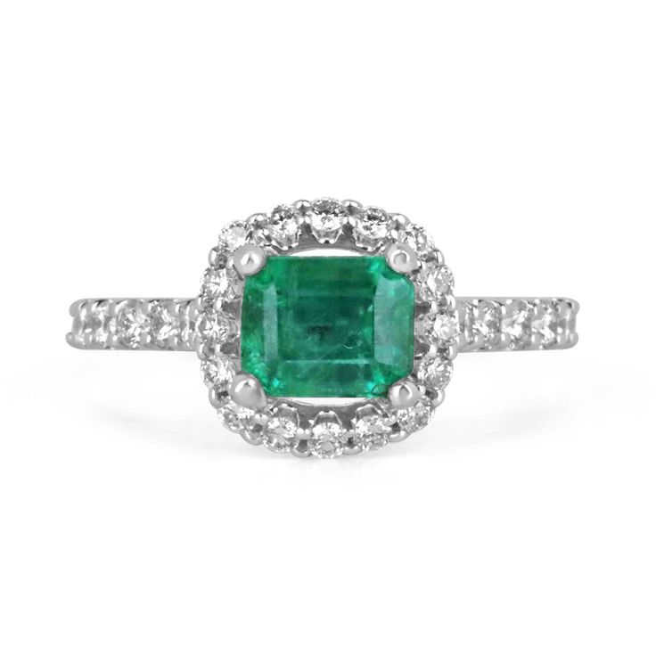 Behold a mesmerizing emerald and diamond engagement ring that captures the essence of timeless elegance. Featuring a magnificent 1.70-carat emerald cut emerald, the vibrant gemstone takes center stage as it is set horizontally, east to west, within secure prongs. The emerald dazzles with a lush and rich green color, boasting beautiful characteristics that reflect its natural allure. Surrounding the emerald, a brilliant round cut diamond halo, intricately pave-set, adds a captivating brilliance and enhances the emerald's beauty. The diamond-adorned shank gracefully extends halfway down, perfectly crafted in lustrous 14k white gold, completing this exquisite symbol of everlasting love. Setting Style: Prong/Pave Setting Material: 14K White Gold Setting Weight: 3.5 Grams Main Stone: Emerald Sh Timeless Emerald Ring With Halo Design, Timeless Emerald Ring With Halo Design For Anniversary, Emerald Halo Design Wedding Ring, Fine Jewelry Emerald Ring With Cushion Cut Diamond, Gia Certified Emerald Diamond Ring, Timeless Style, Classic Green Diamond Cluster Ring, Diamond Emerald Ring With Cushion Cut And Prong Setting, Emerald Diamond Ring With Cushion Cut And Prong Setting, May Birthstone Asscher-cut Diamond Ring