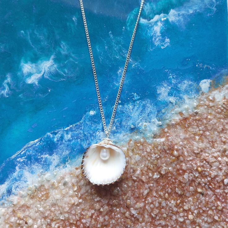 Embrace the beauty of the ocean with our handcrafted Seaside Elegance necklace, a stunning piece that captures the essence of the shore. This necklace features a natural seashell pendant, carefully selected for its unique shape and intricate patterns, paired with a lustrous freshwater pearl that adds a touch of elegance. Each necklace is lovingly handcrafted, ensuring that no two pieces are exactly alike--just like the treasures you find on the beach. The combination of organic elements and time Necklace Seashell, Sunrise Shell, Pearl Jewelry Gift, Organic Elements, Seashell Pendants, Shell Necklaces, Intricate Patterns, Favorite Things Gift, Pearl Jewelry