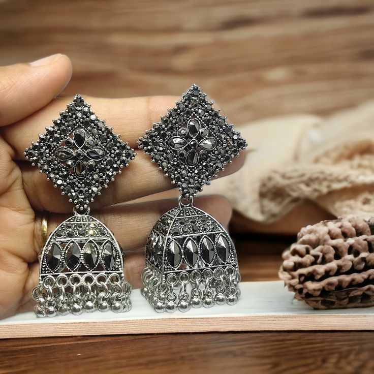 Oxidized Silver Plated Jhumka earrings! These exquisite pieces showcase the perfect blend of traditional and contemporary style, creating a striking statement piece for any occasion. Crafted with meticulous attention to detail, these jhumka earrings feature a unique oxidized silver plating that adds an edgy and vintage touch to the design. The intricate patterns and delicate filigree work exude a sense of elegance, making these earrings an absolute must-have for those who appreciate exquisite jewelry.   Care Instructions: To keep the beauty of these oxidized silver plated jhumka earrings intact, we recommend avoiding contact with water, perfumes, and harsh chemicals. It is best to store them in a cool, dry place when not in use. Gently wipe them with a soft, dry cloth after each wear to re Jhumka Collection, Oxidized Earrings, Pretty Jewelry Necklaces, Silver Jewellery Indian, Antique Jewelry Indian, Indian Earrings, Pretty Jewelry, Fancy Jewellery, Jhumka Earrings