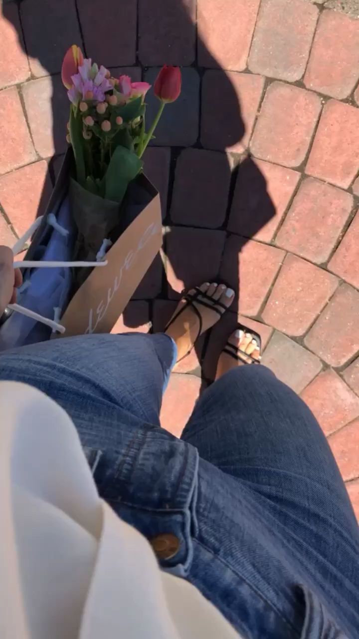 a person sitting on a bench with flowers in their lap