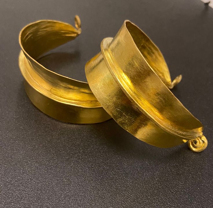 A simple but striking piece of African handmade statement cuff bangle in brass gold that completes gives an edge to your style. Handmade in Mali, West Africa inspired by jewellery worn by the Fulani women to display their wealth and nobility.  Find the gold earrings here https://www.etsy.com/uk/listing/1109194210/fulani-earrings?click_key=ea7e7038731be9c3943107952dfd5b6f66cb2f71%3A1109194210&click_sum=0344547d&ga_search_query=Gold&ref=shop_items_search_2&crt=1 Find the gold necklace here Gold Cuff Bangle, Fulani Earrings, African Print Shirt, Hand Candy, Exotic Jewelry, Handmade African, Gold Cuffs, African Jewelry, Brass Gold