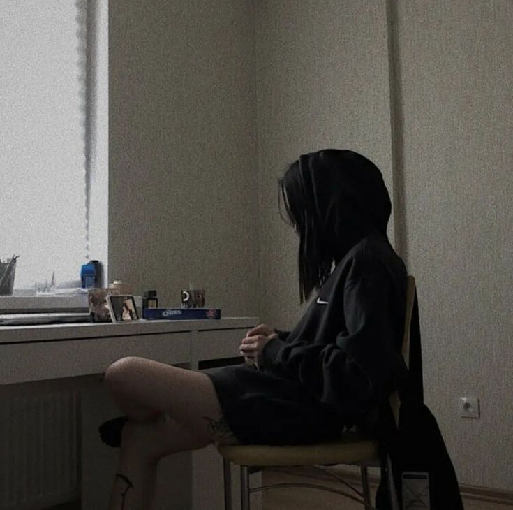 a person sitting at a desk in front of a window