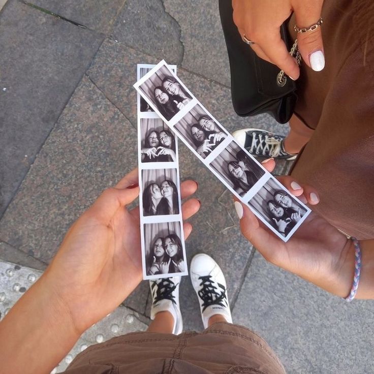 two people are holding up photos with their hands