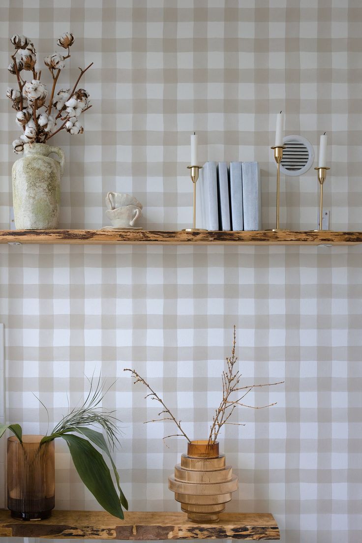 two shelves with vases and books on them