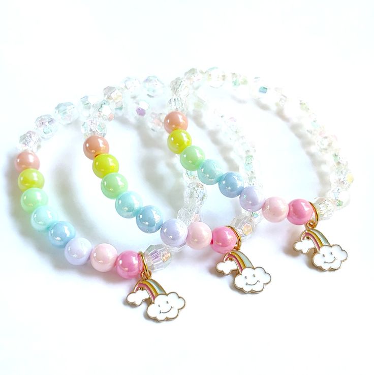 These adorable bracelets are the perfect favor for your little one's rainbow themed party! Each bracelet features a pastel enameled rainbow charm, a rainbow of pastel 10mm beads and white acrylic pearls strung with durable stretch floss cord. Each bracelet comes individually packaged in organza bags. Not quite what you are looking for? Request a custom order! I can match your bracelets to your other party decor. To be the first to know about new items, sales and giveaways, mark my shop as a favo Adjustable Rainbow Beaded Bracelets Playful Style, Adjustable Rainbow Beaded Bracelets In Playful Style, Adjustable Rainbow Beaded Bracelets, Playful Style, Personalized Adjustable Rainbow Jewelry, Adjustable Rainbow Friendship Bracelets For Birthday, Adjustable Personalized Rainbow Jewelry, Personalized Kawaii Multicolor Jewelry, Playful White Jewelry With Charms, Kawaii Multicolor Personalized Jewelry