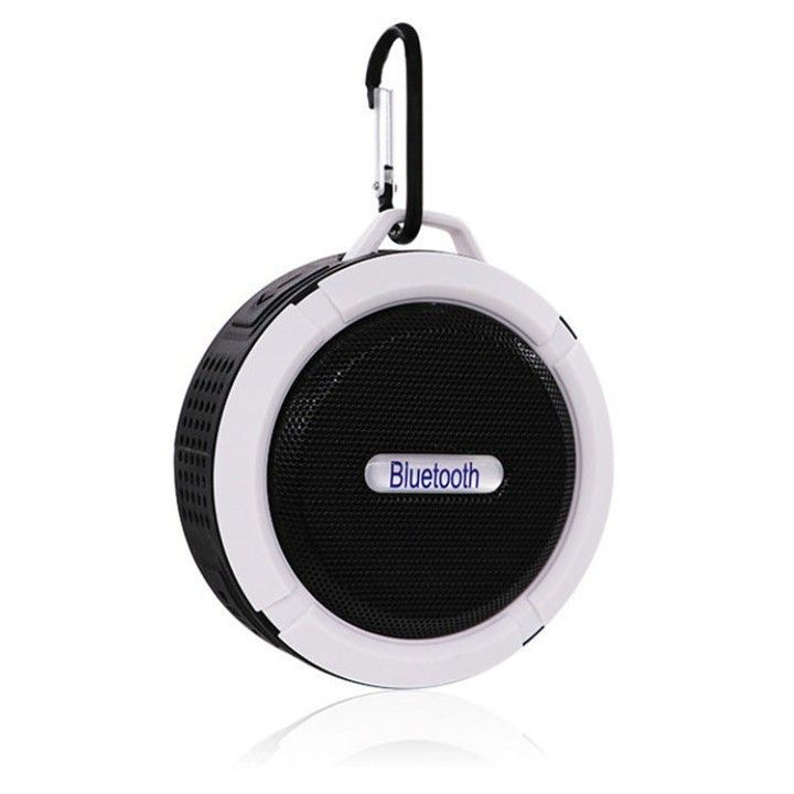 the bluetooth portable speaker is white and has a black hook on it's side