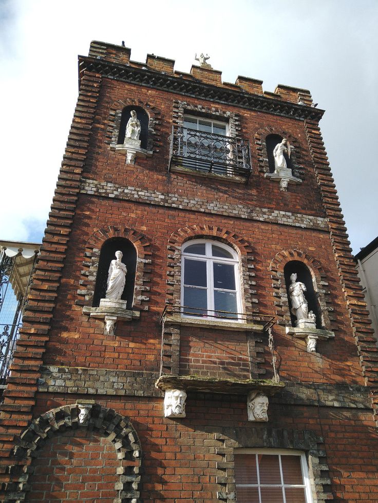 an old brick building with statues on the windows